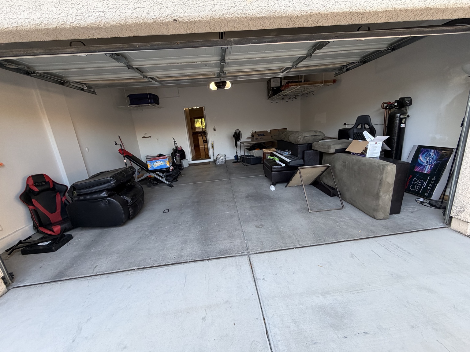 Before: couches, chairs, exercise equipment and boxes in a garage